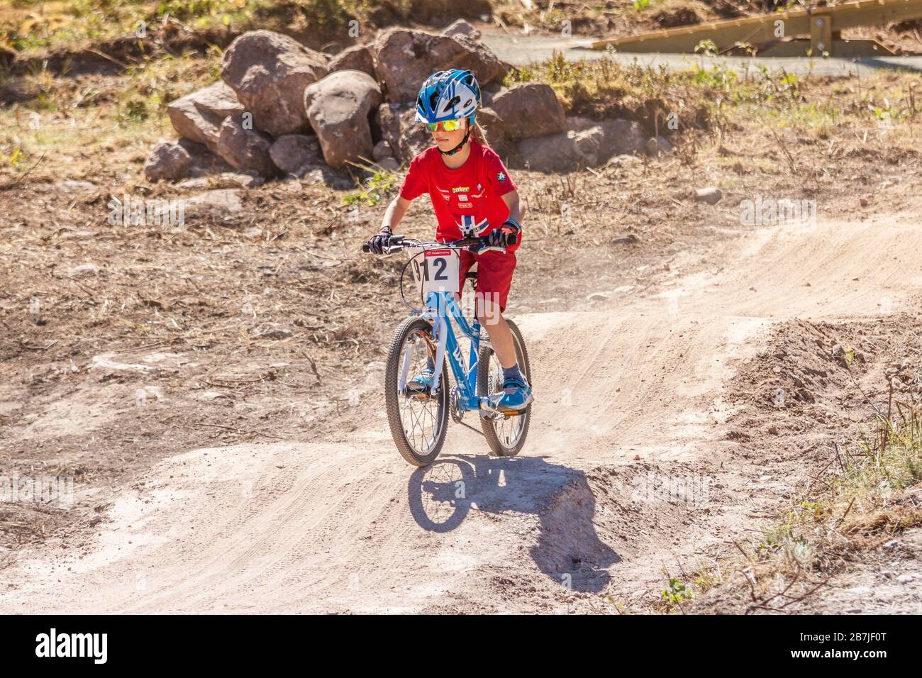 Children cycling on a pump track on a bright sunny day. Stock Photo
