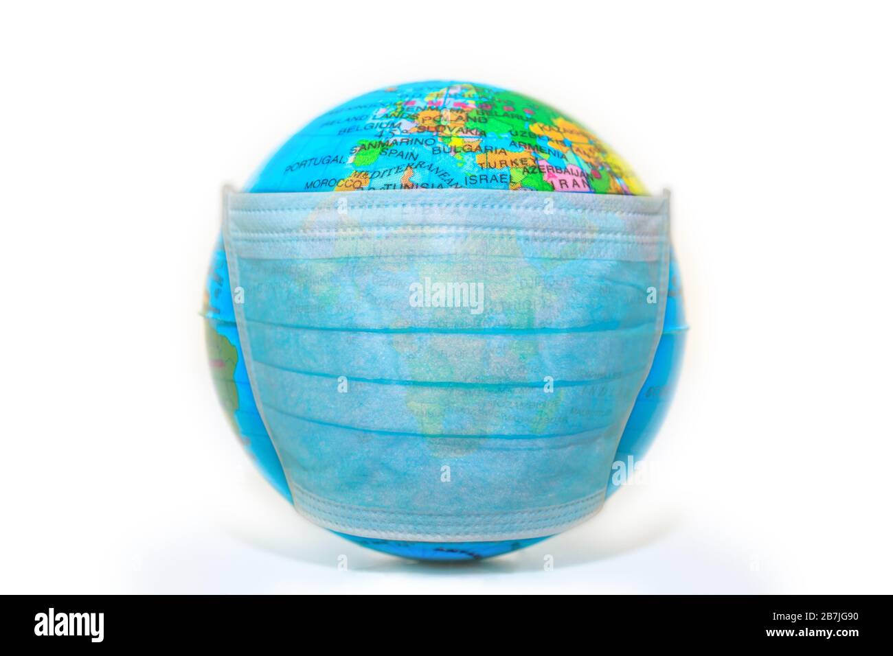 blue disposable face mask on a sick world globe isolated on white background. Concept of epidemic flu and pandemic emergency worldwide for COVID 19 Stock Photo