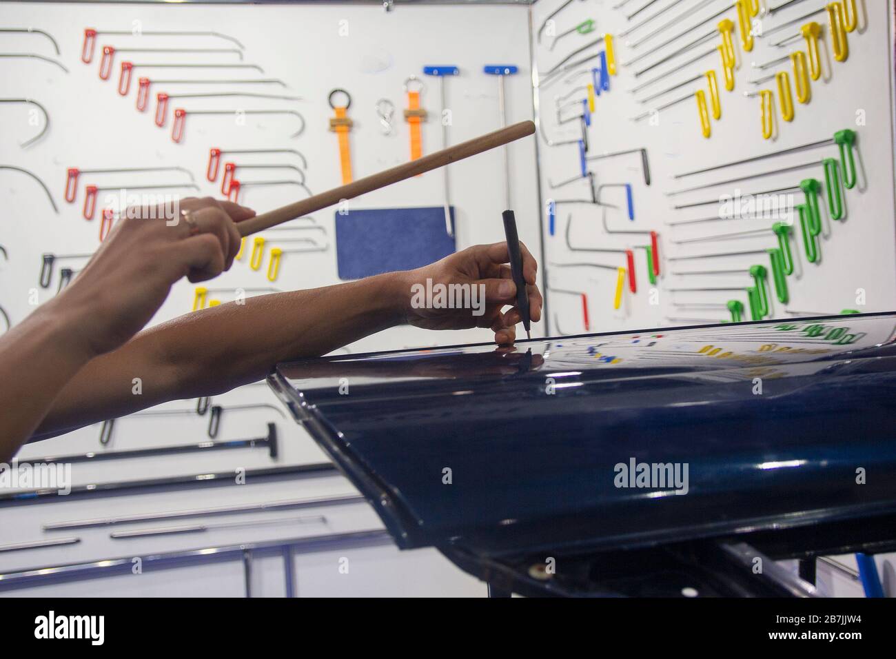 Hands of the worker working on straightening the car. Car service Stock Photo