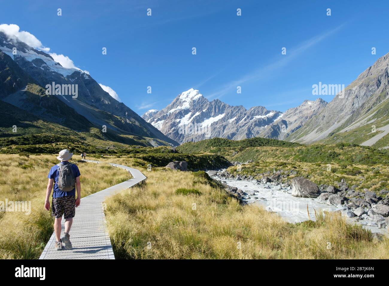Man on trail with Glaciers and snow-topped mountain, Hooker Track, Aoraki/Mount Cook National Park, South Island, New Zealand Stock Photo