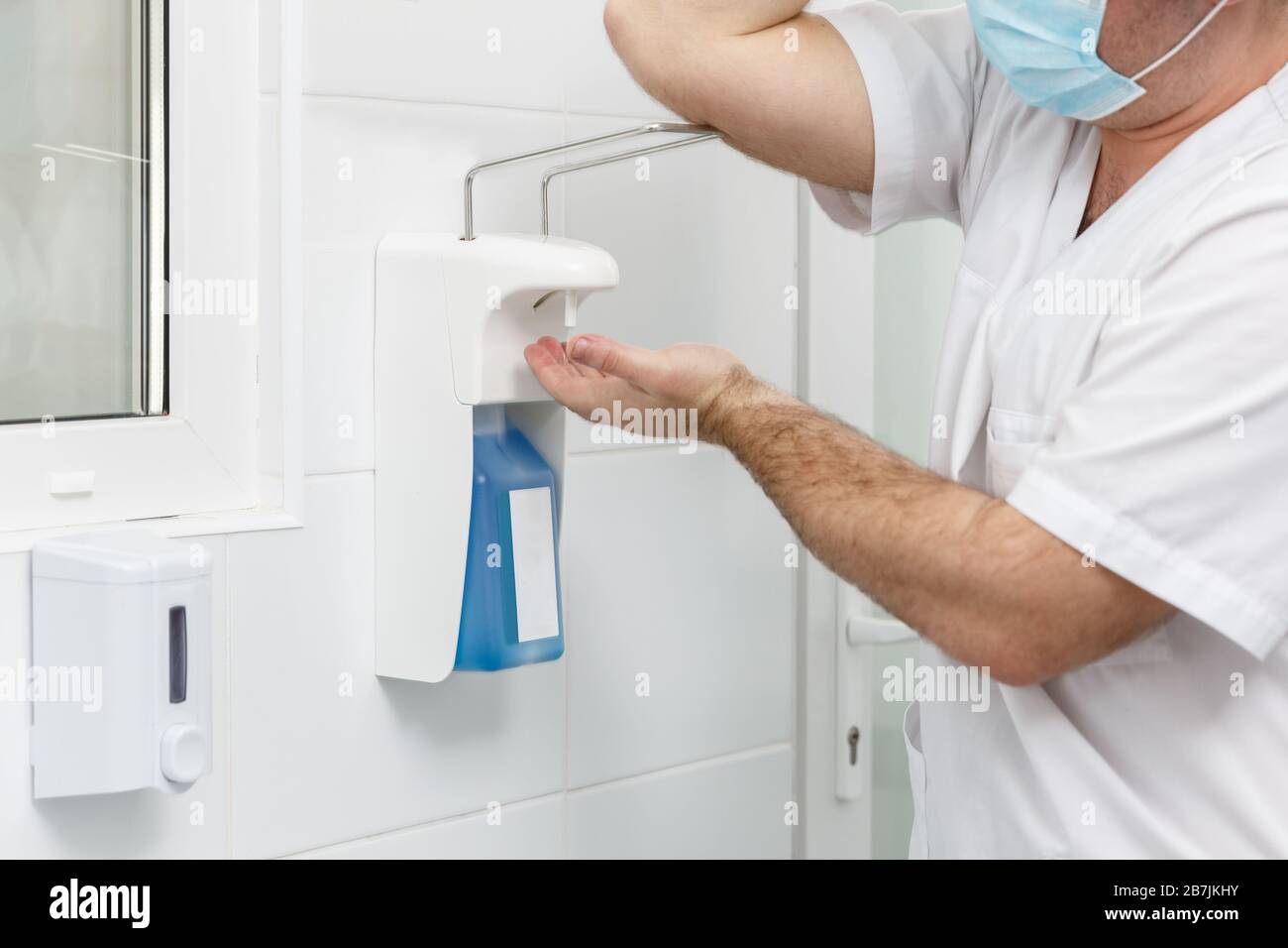 Doctor washing hands using disinfecting liquids in a surgical clinic