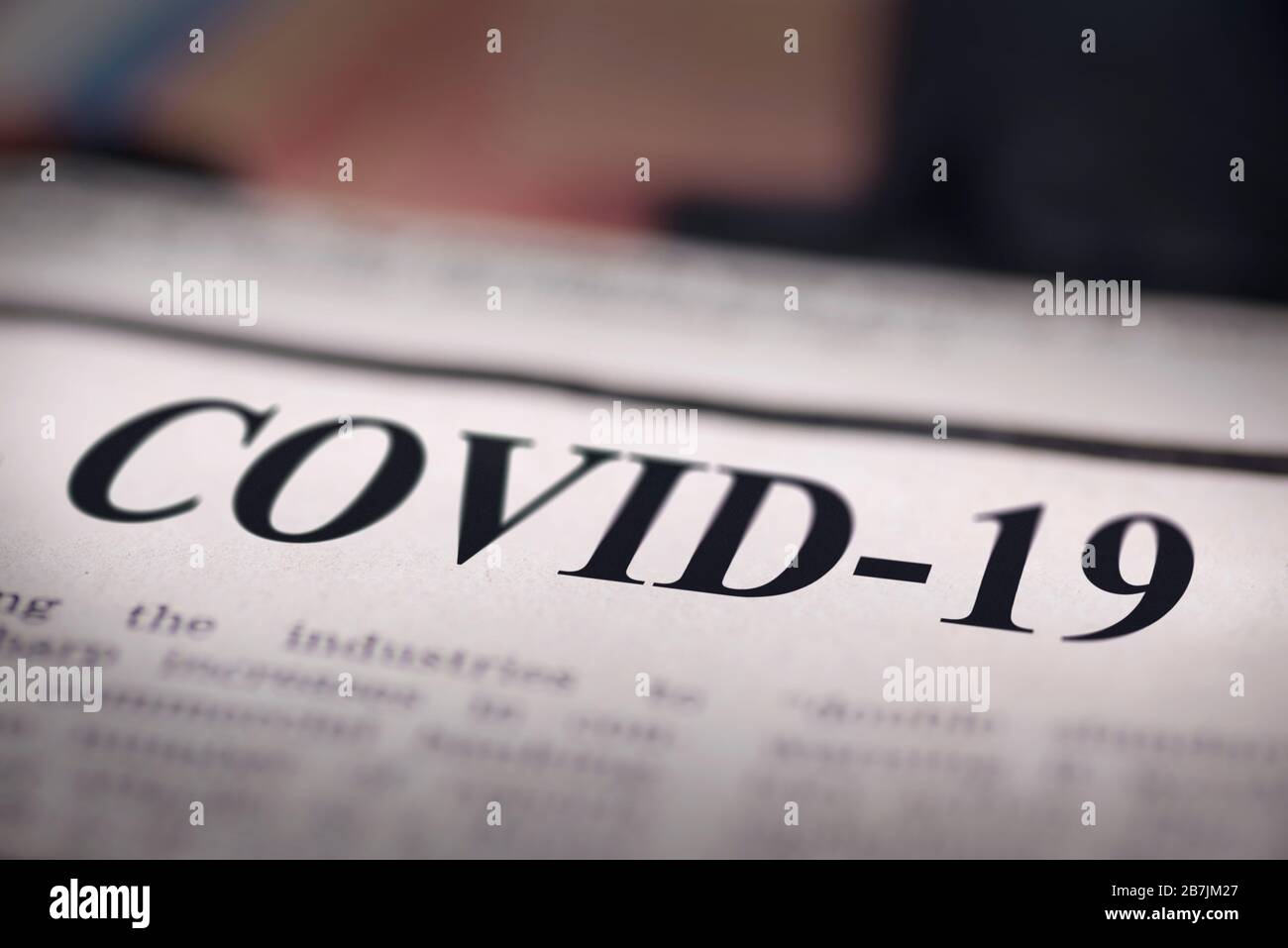 COVID-19 written newspaper close up shot to the text. Stock Photo