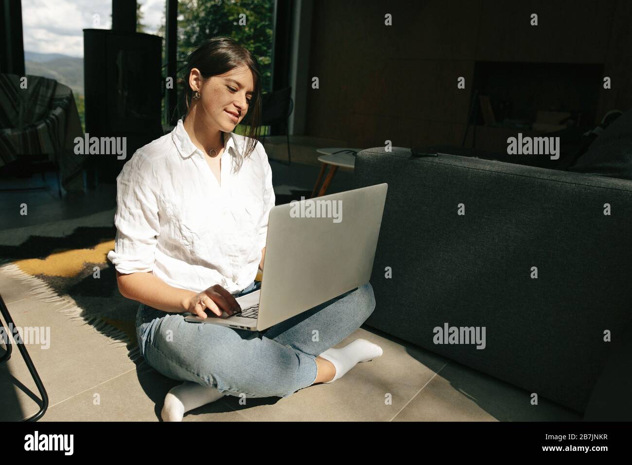 Happy Stylish Girl Sitting On Floor With Laptop In Sunny Light