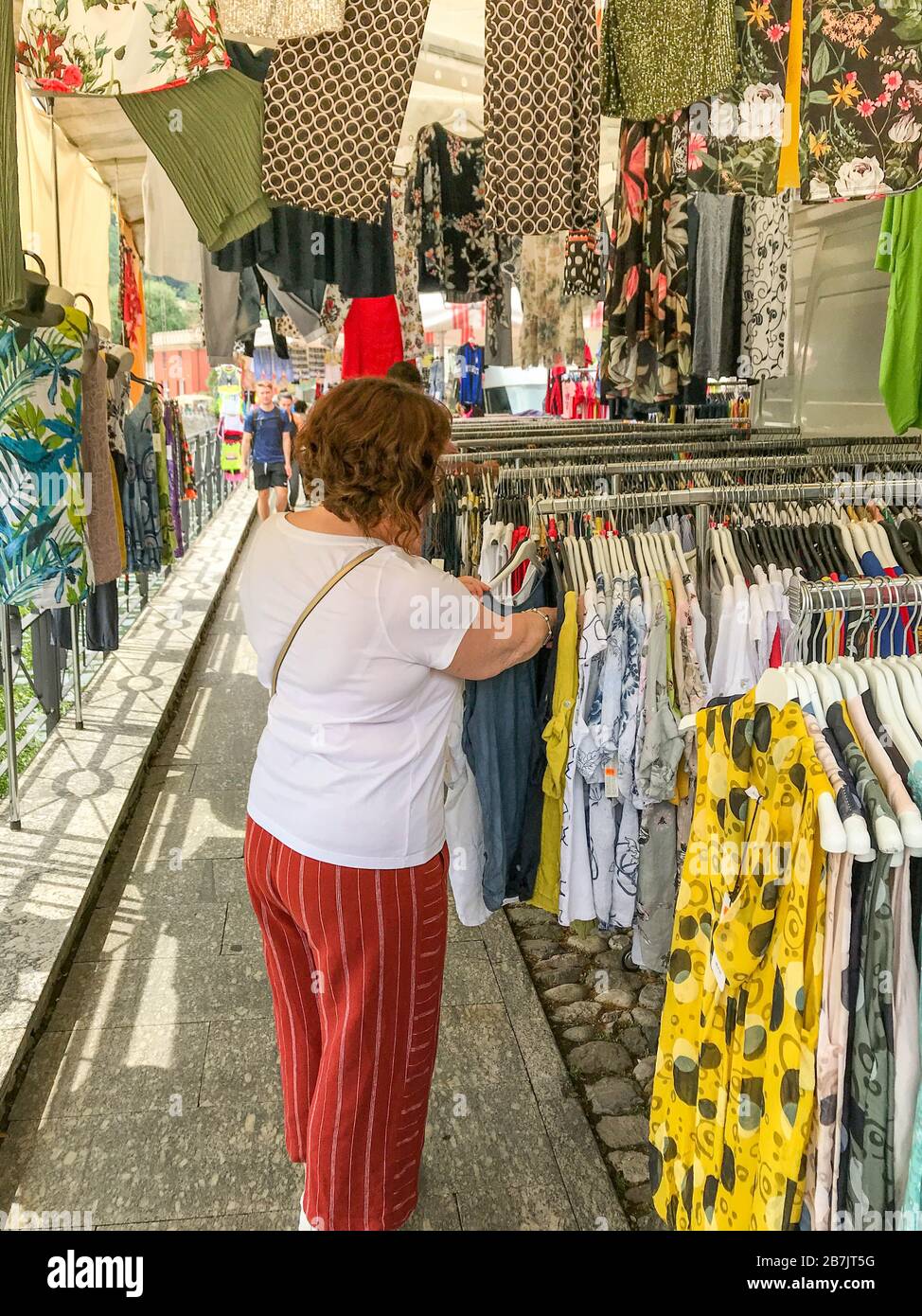 LENNO, LAKE COMO, ITALY - JUNE 2019: Person looking at clothes on a stall in the market in Lenno on Lake Como. Stock Photo