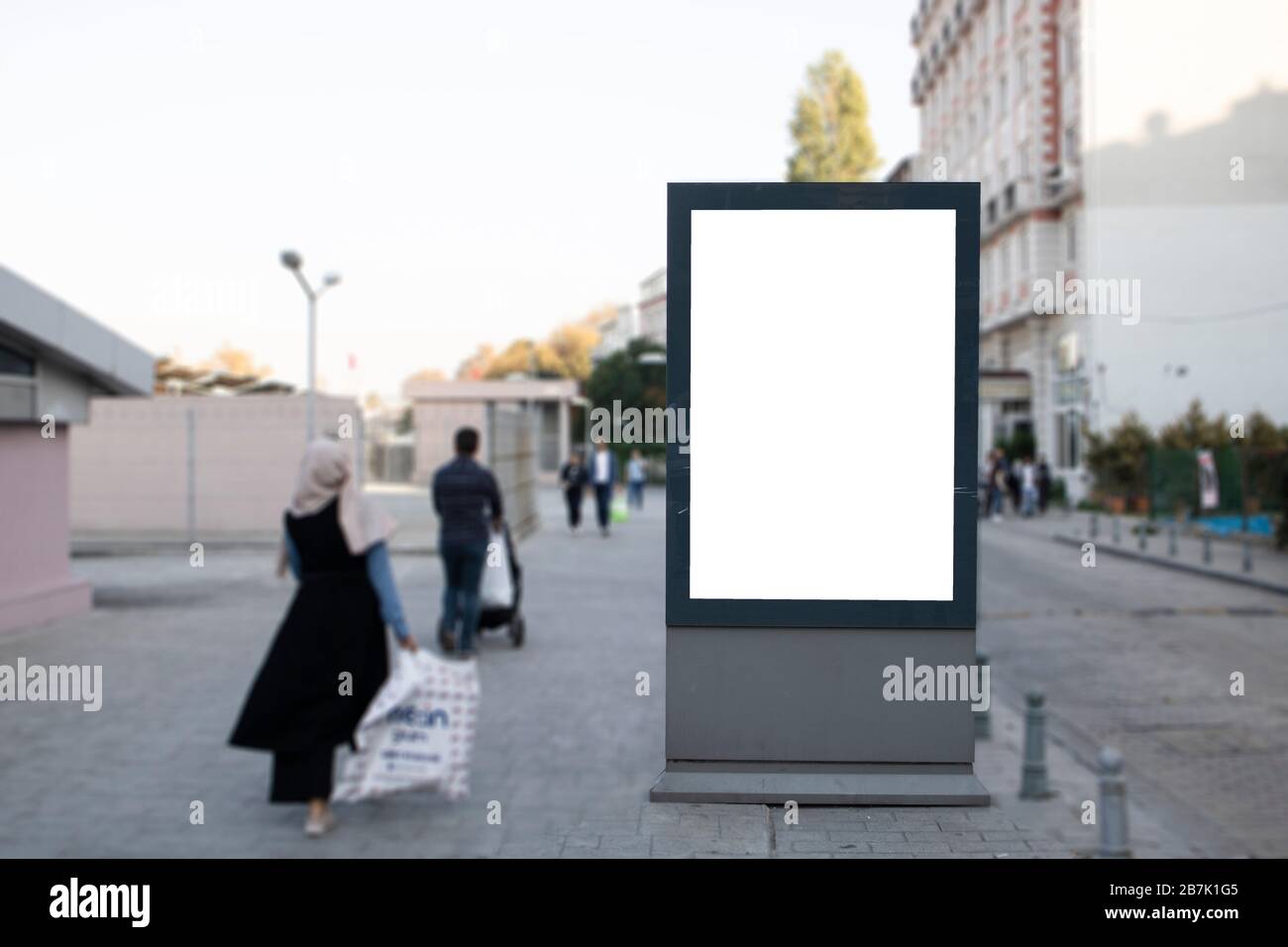 Empty rectangular bilboard. Photographed on the edge. Walking people. Stock Photo