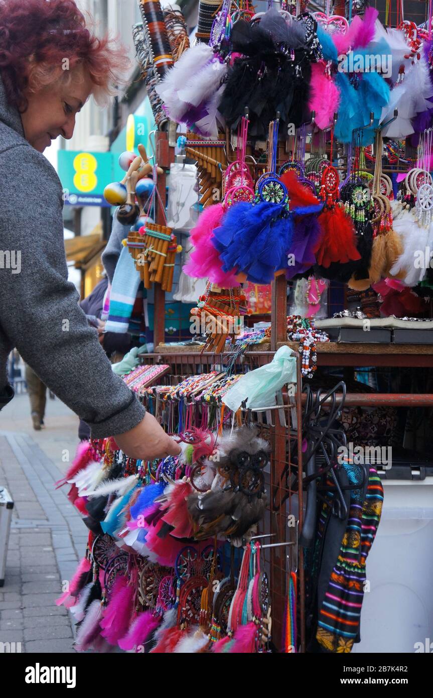 a woman shopping at a street market stall selling colorful clothing accessories Stock Photo