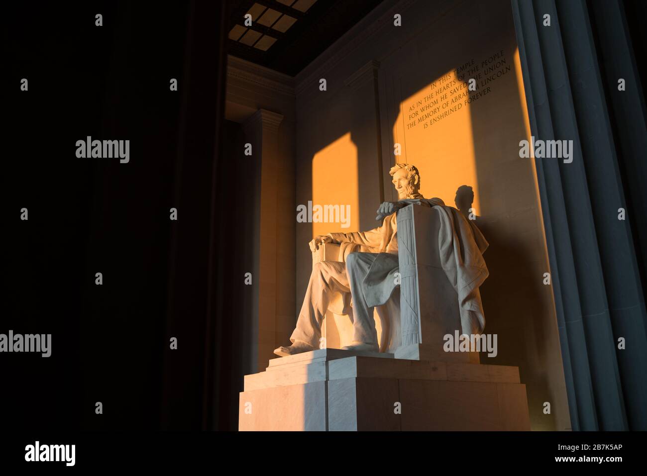 WASHINGTON DC, United States - Early morning at the Lincoln Memorial in Washington DC. Sitting on the western end of the National Mall, it commemorates the 16th president of the United States, Abraham Lincoln. This photo was taken around the spring solstice. With the sun rising directly in the east, the light briefly shines directly onto the massive statue of Lincoln that sits deep inside the building. Stock Photo