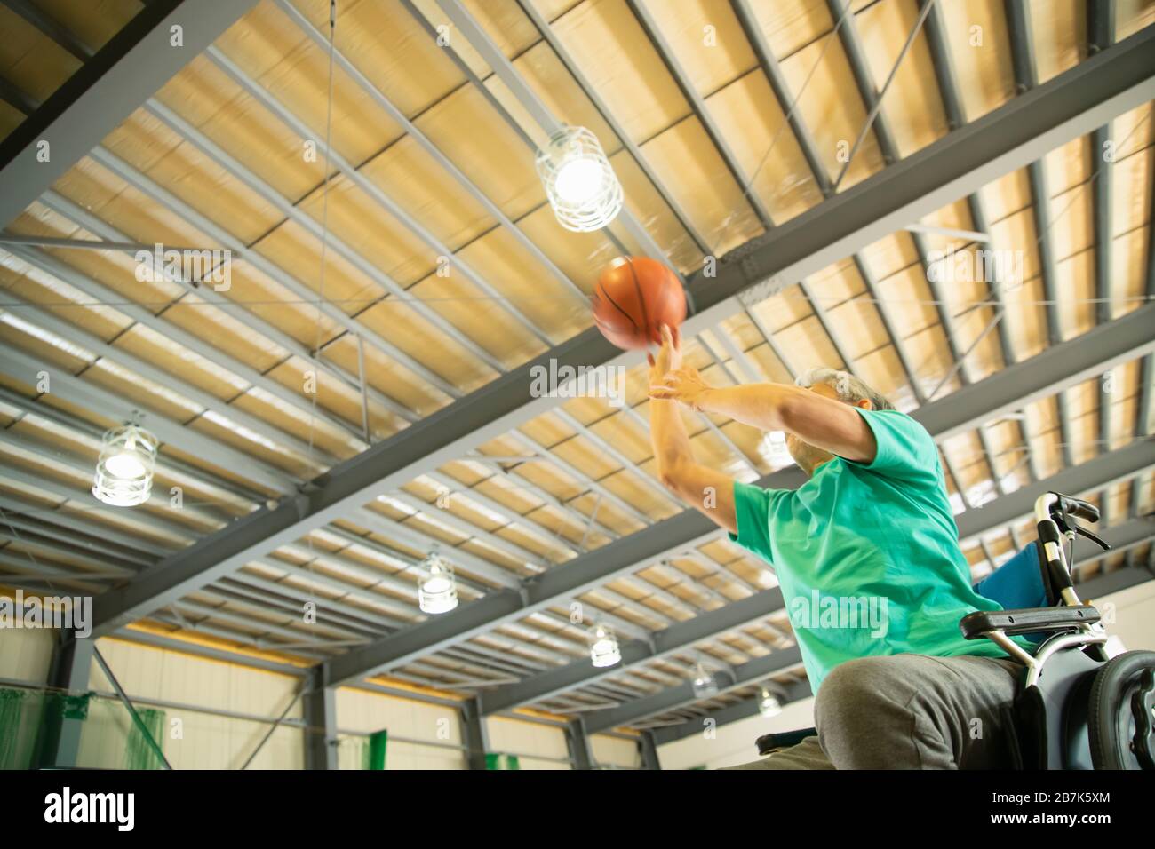 Senior man in wheelchair shooting basket ball Stock Photo