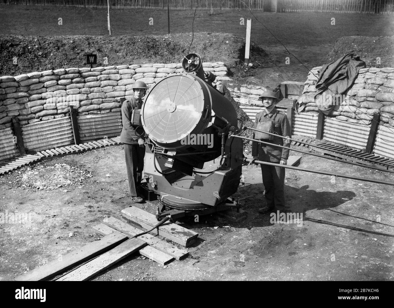 An anti-aircraft searchlight and crew at the Royal Hospital at Chelsea in London, 17 April 1940. Anti-aircraft searchlight and crew at the Royal Hospital at Chelsea in London, 17 April 1940. This is the 90mm model. The tube at the top of the light is a fan that cools the interior. Stock Photo