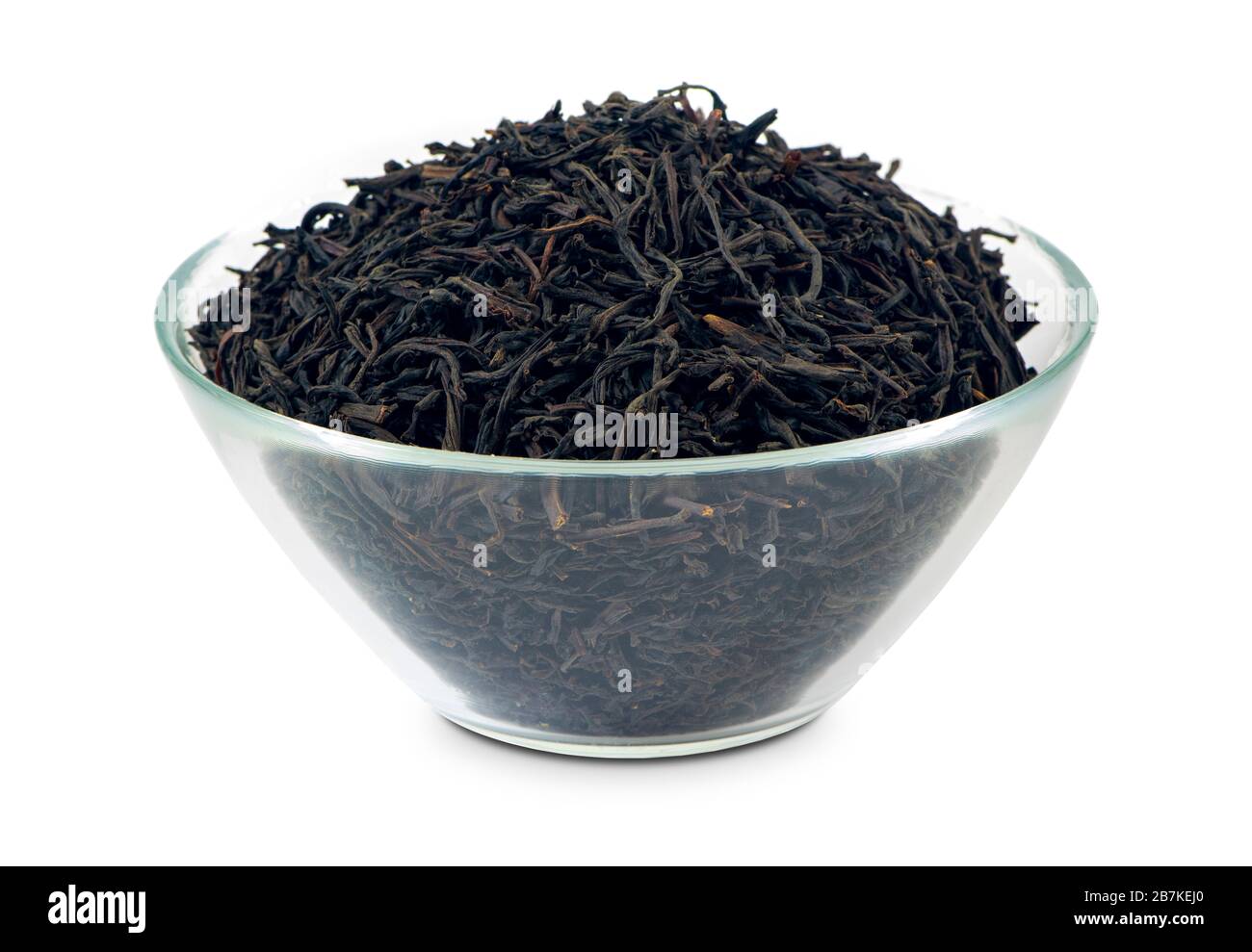 Black loose tea in a glass bowl, isolated on white background. Good quality Ceylon tea with big opa leaves. Stock Photo