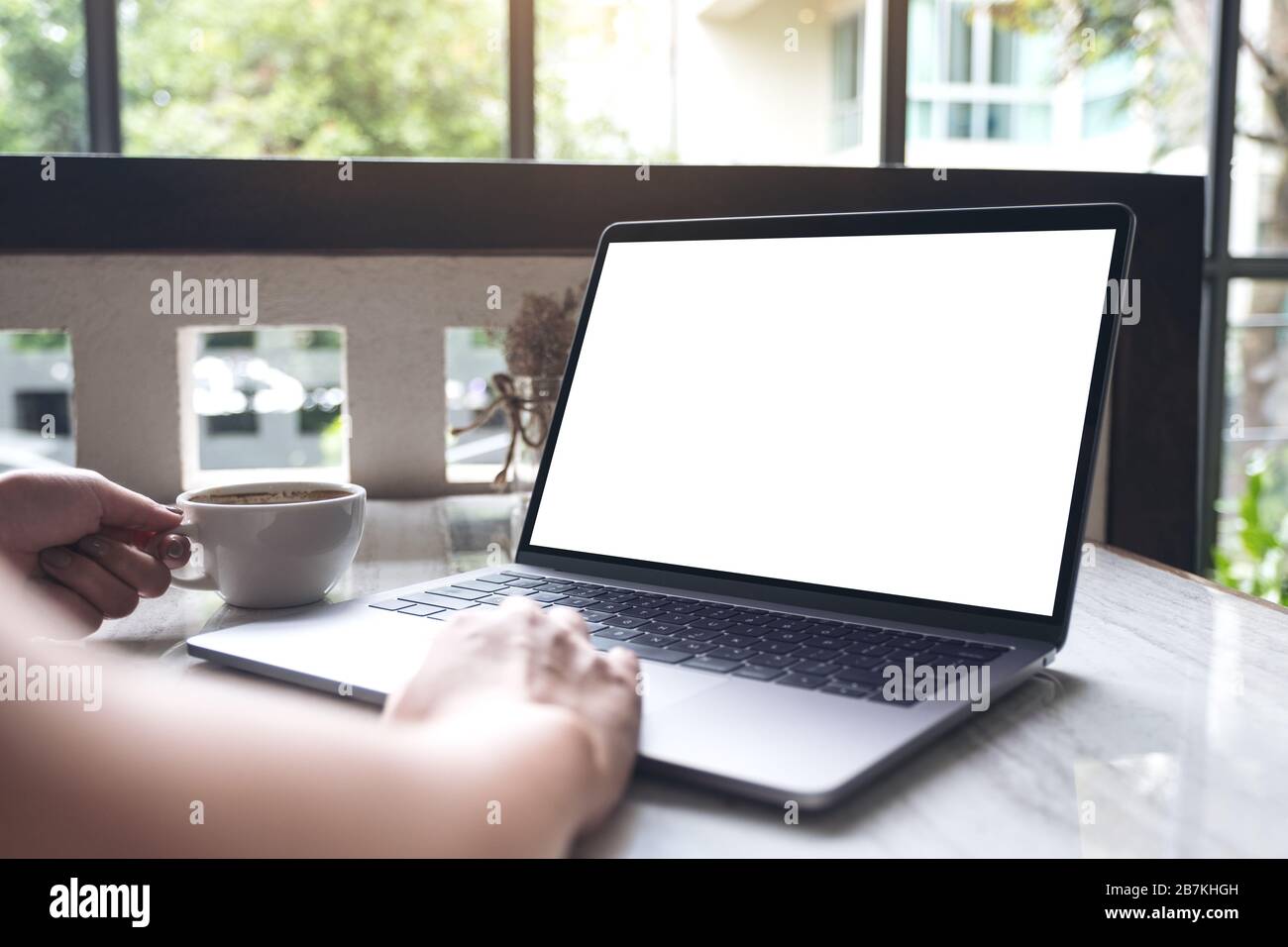 Mockup image of a woman using and typing on laptop with blank white ...