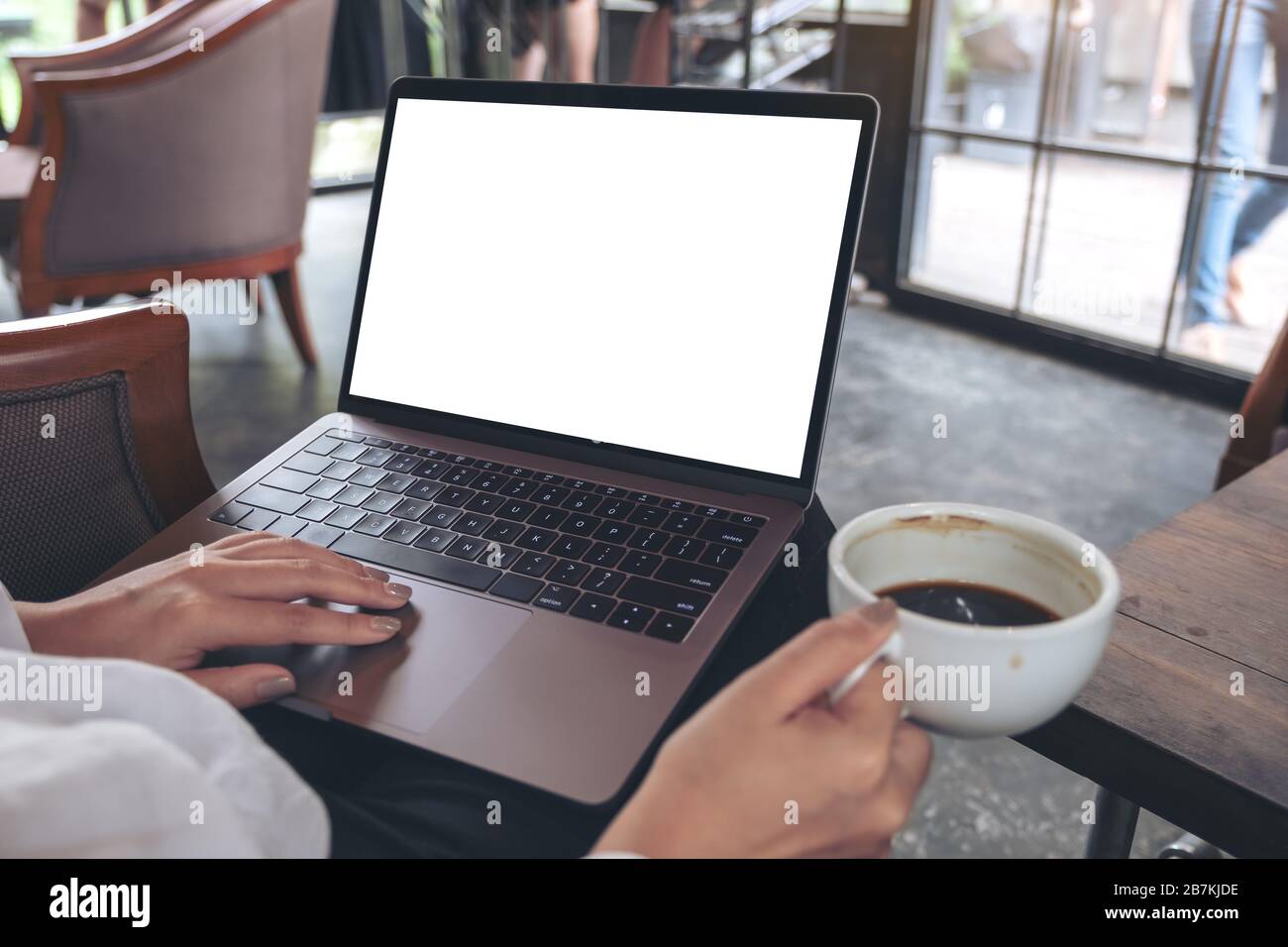 Mockup image of a woman using and typing on laptop with blank white ...