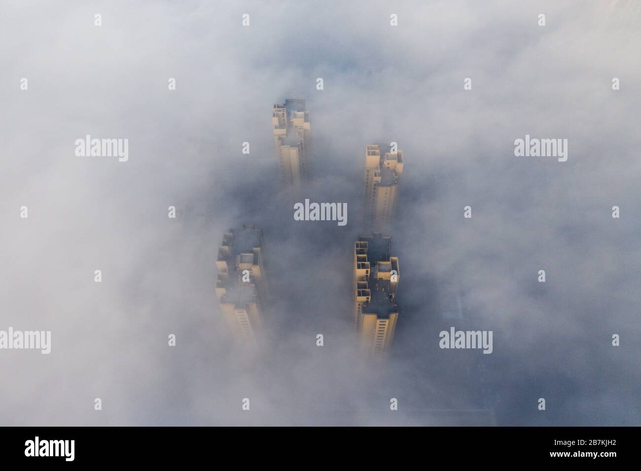 Skyscrapers are enveloped by fog in Huaibei city, east China's Anhui province, 12 February 2020. Stock Photo