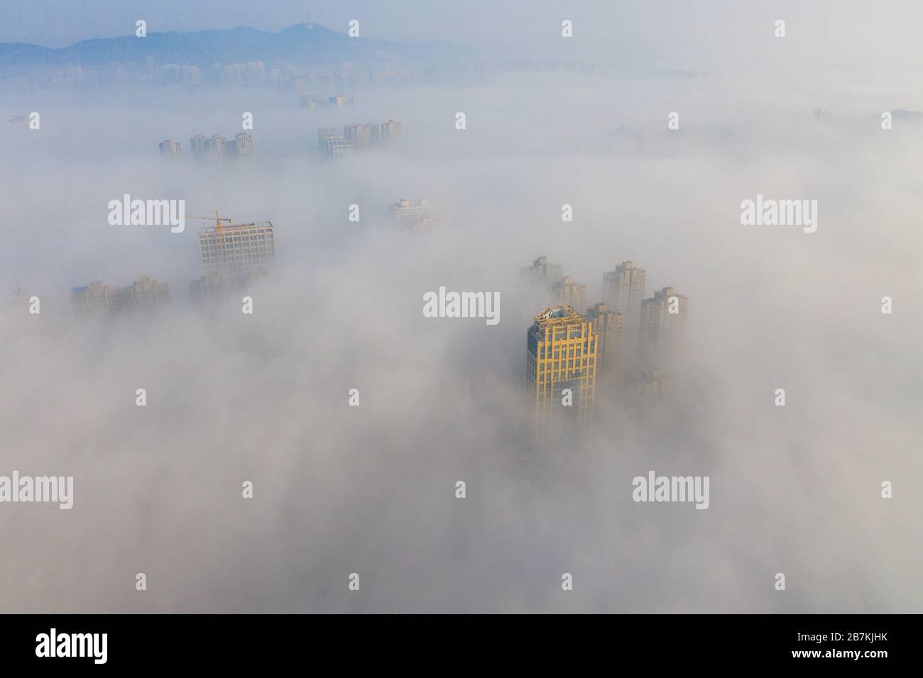 Skyscrapers are enveloped by fog in Huaibei city, east China's Anhui province, 12 February 2020. Stock Photo