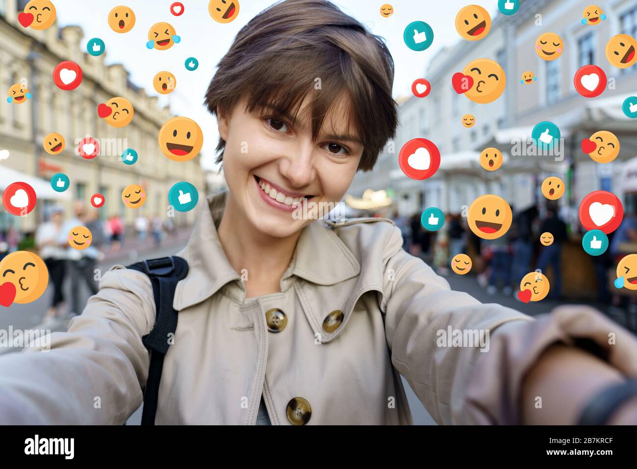 Happy young girl hold modern smart phone make selfie portrait urban background. Stock Photo