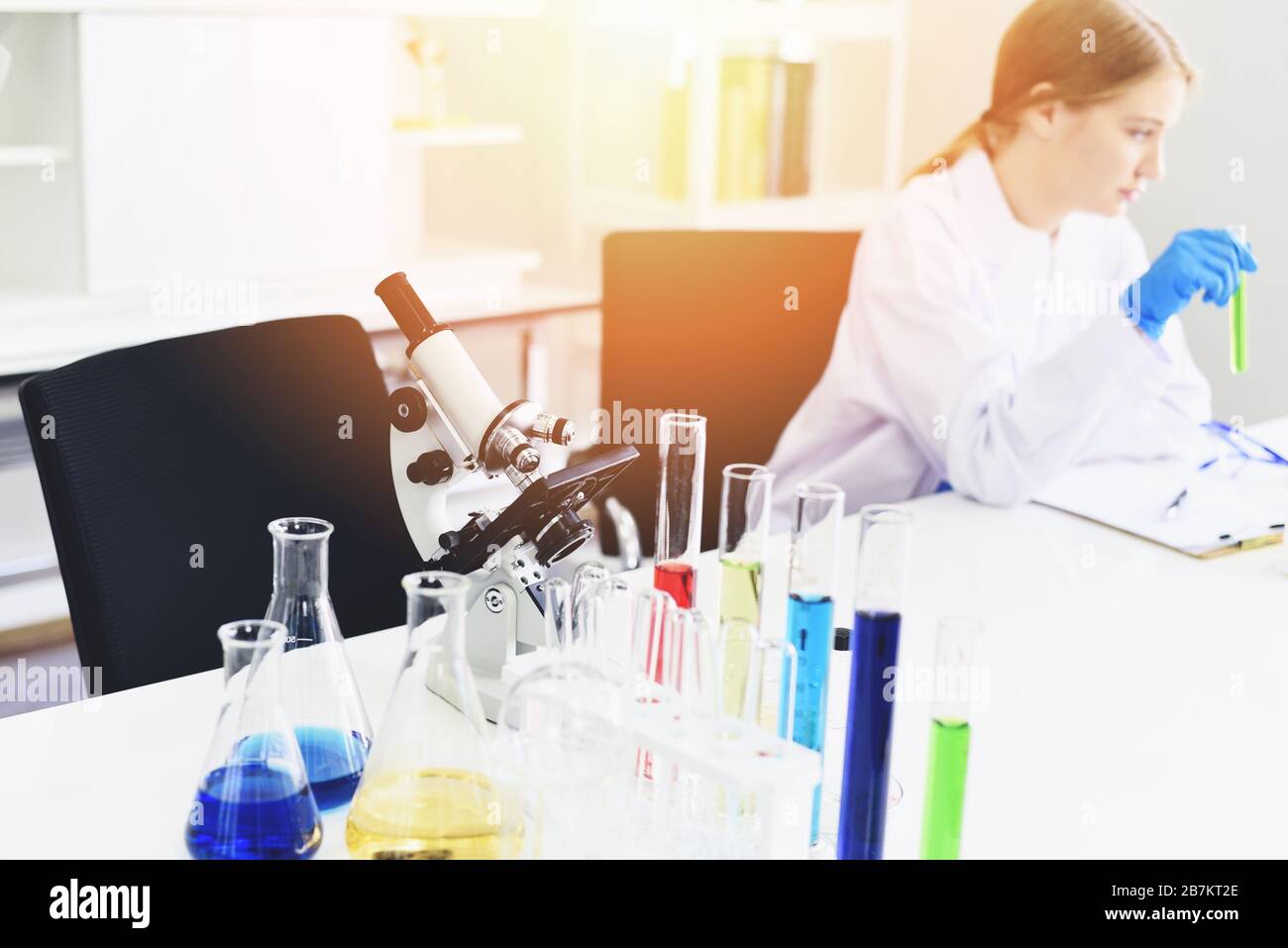 Young female scientist doing some research working conduct experiments and microscope in modern laboratory / Scientists in lab biochemistry genetics f Stock Photo
