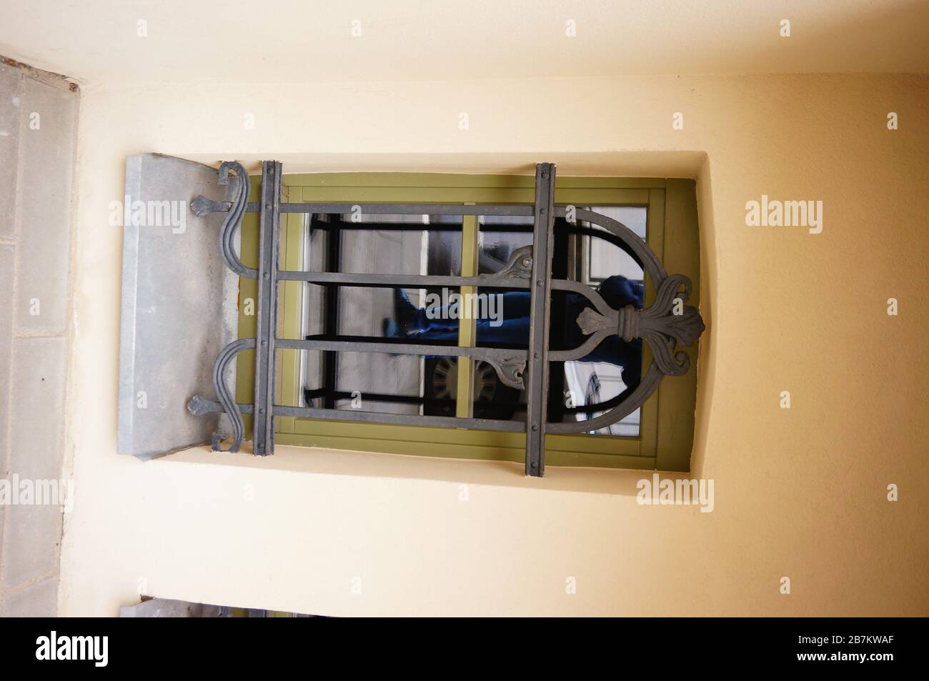 Vertical shot of the legs of a male mirrored in the window with sashes Stock Photo