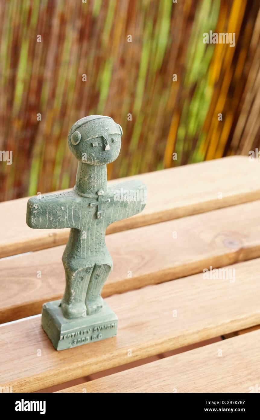 Vertical closeup shot of the Cyprus fertility symbol sculpture on a wooden table Stock Photo