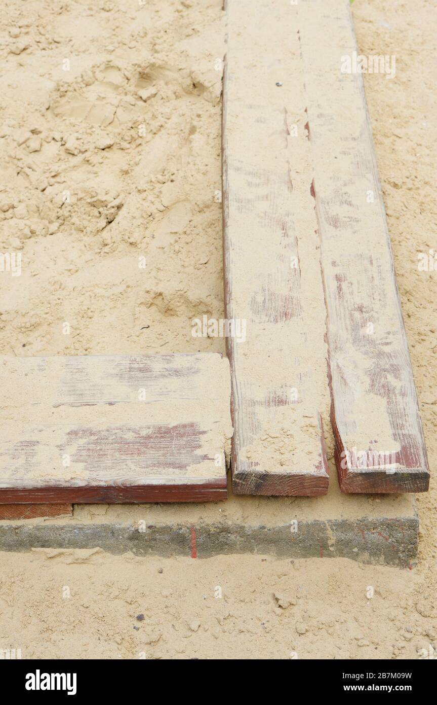 High angle shot of plywood edges in the sand during daytime Stock Photo