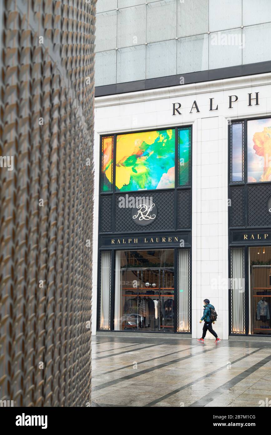 Woman walking past luxury store, Jingan, Shanghai, China Stock Photo