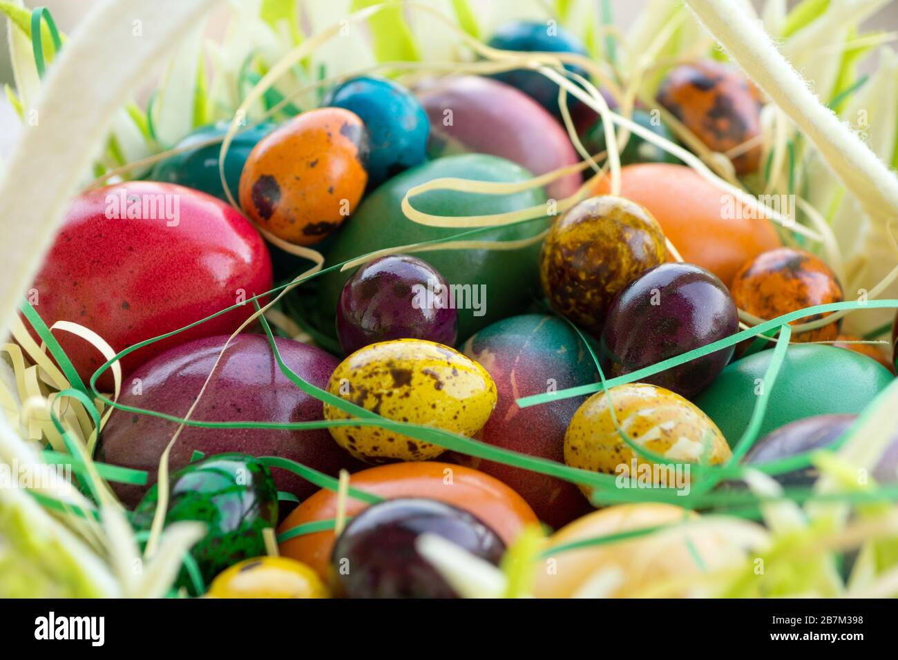 Multicolored painted Easter eggs in hand basket Stock Photo