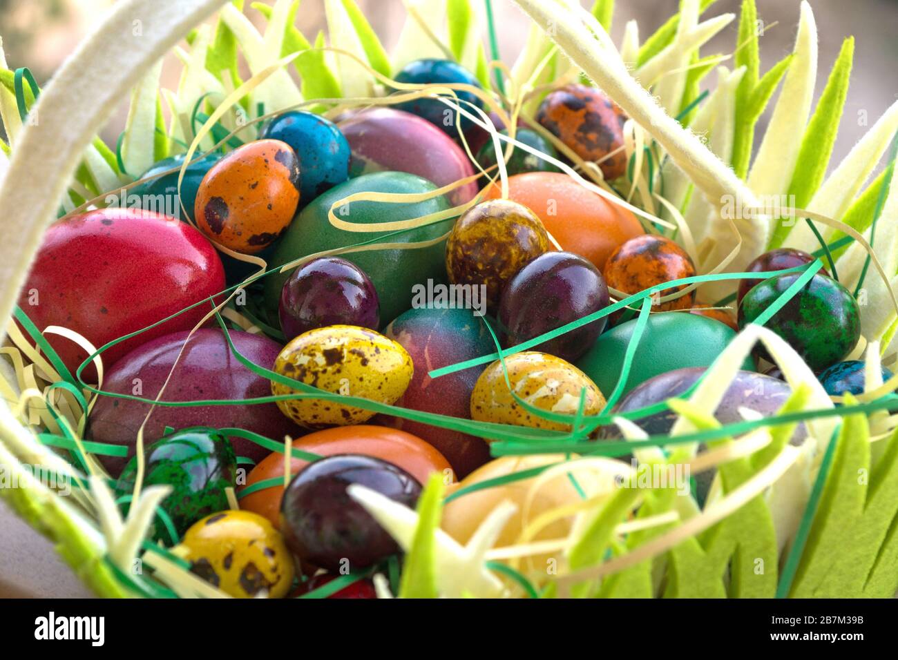 Multicolored painted Easter eggs in hand basket Stock Photo