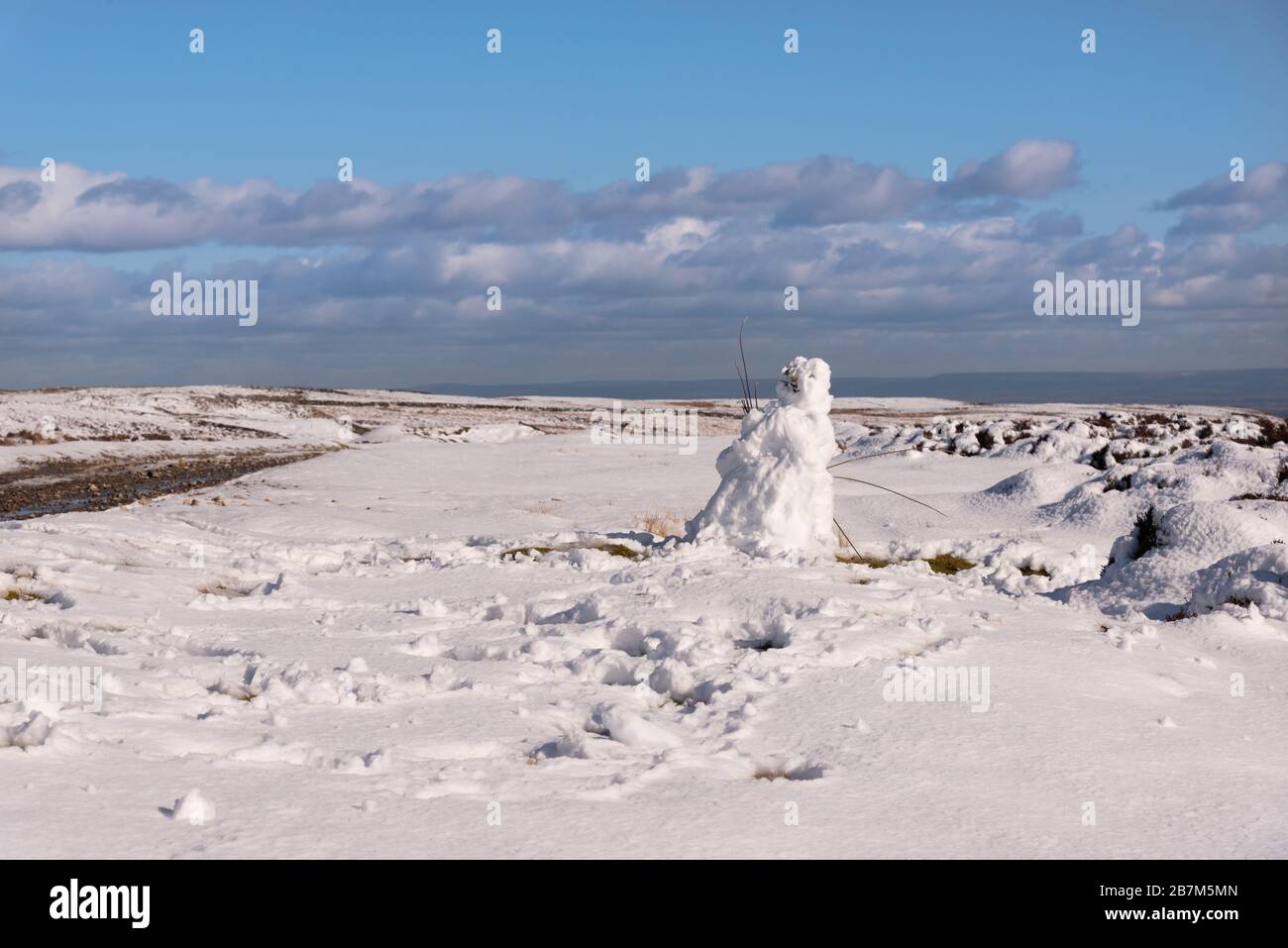 Snowman on the moor with blue sky above Stock Photo - Alamy