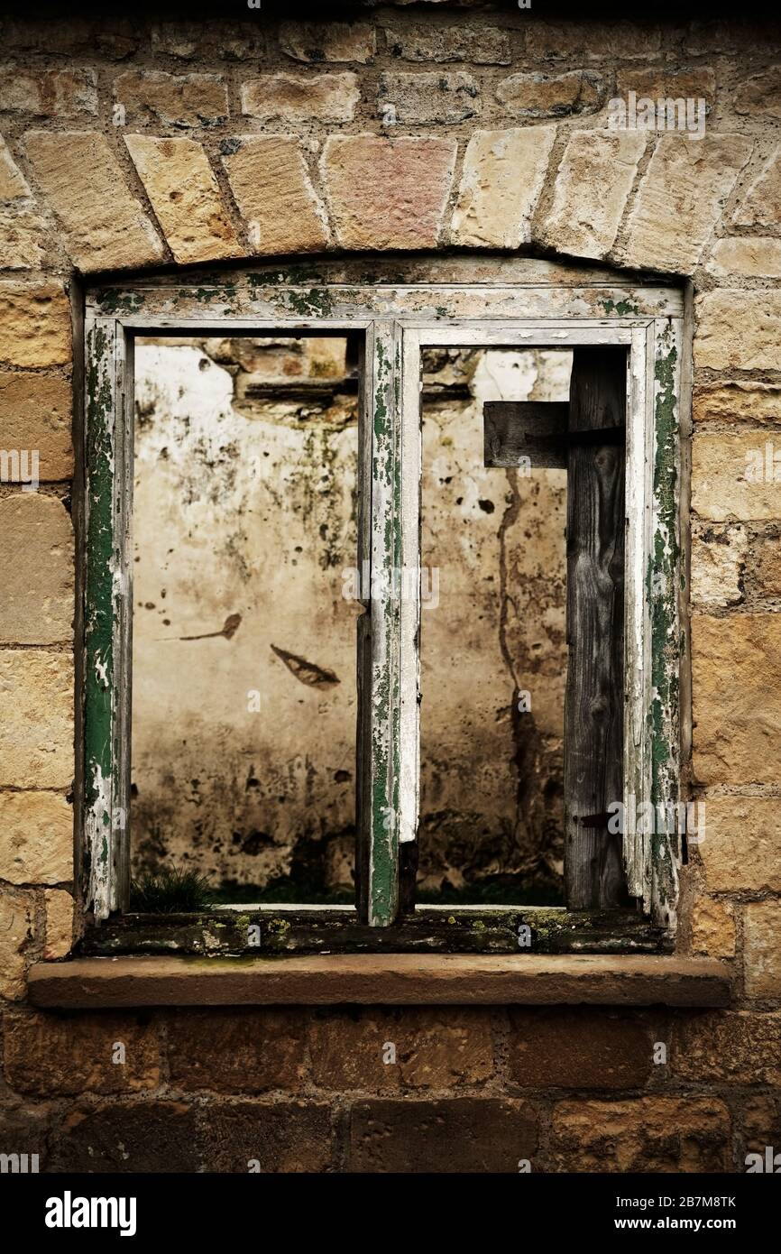 Old rotten windowframe in derelict stone building. Stock Photo