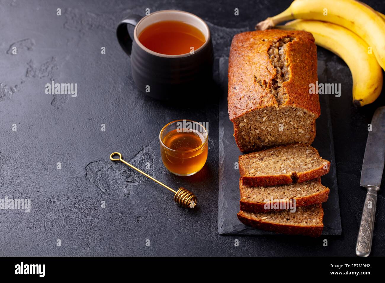 Healthy vegan oat and banana loaf bread, cake. Dark background. Copy space. Stock Photo