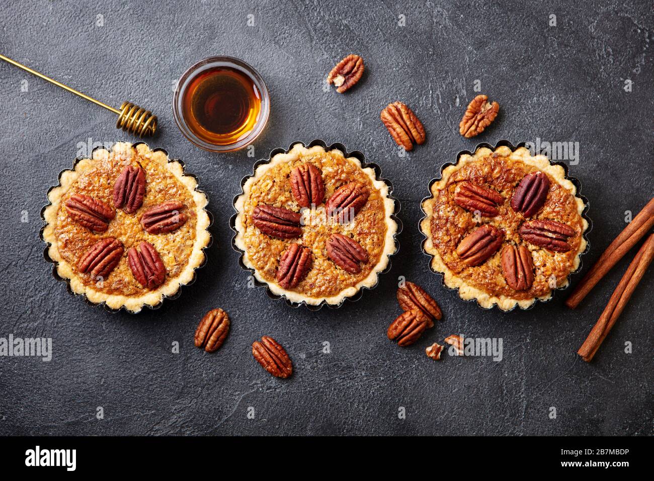 Pecan pies, mini tarts. Traditional Thanksgiving dessert. Dark background. Copy space. Top view. Stock Photo