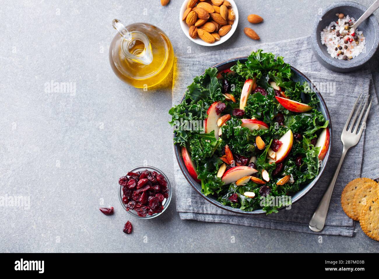 Kale salad with apples and nuts. Grey background. Copy space. Top view. Stock Photo
