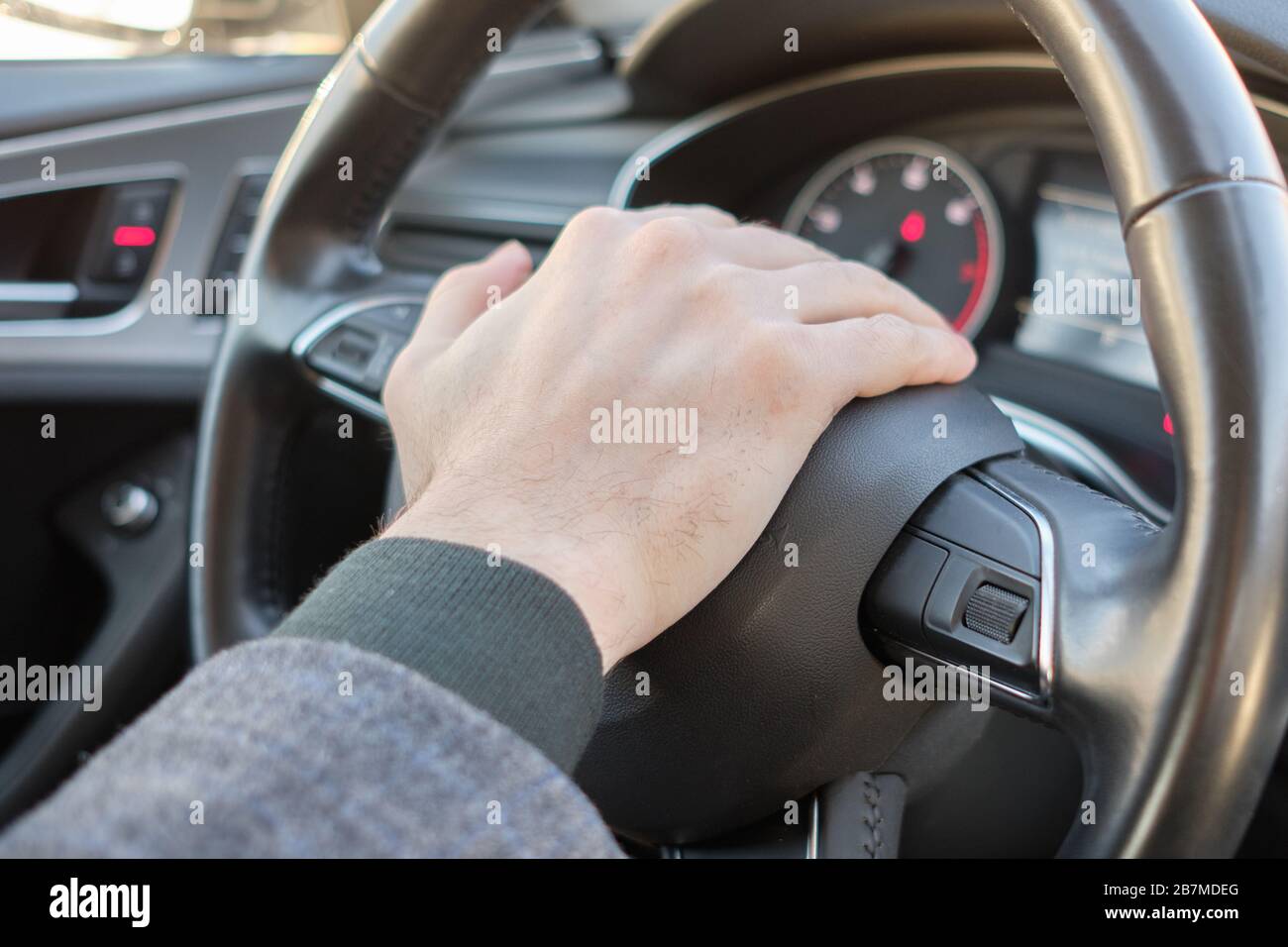 A man in a modern car. Hand presses the beep and gives a signal. Close up  Stock Photo - Alamy