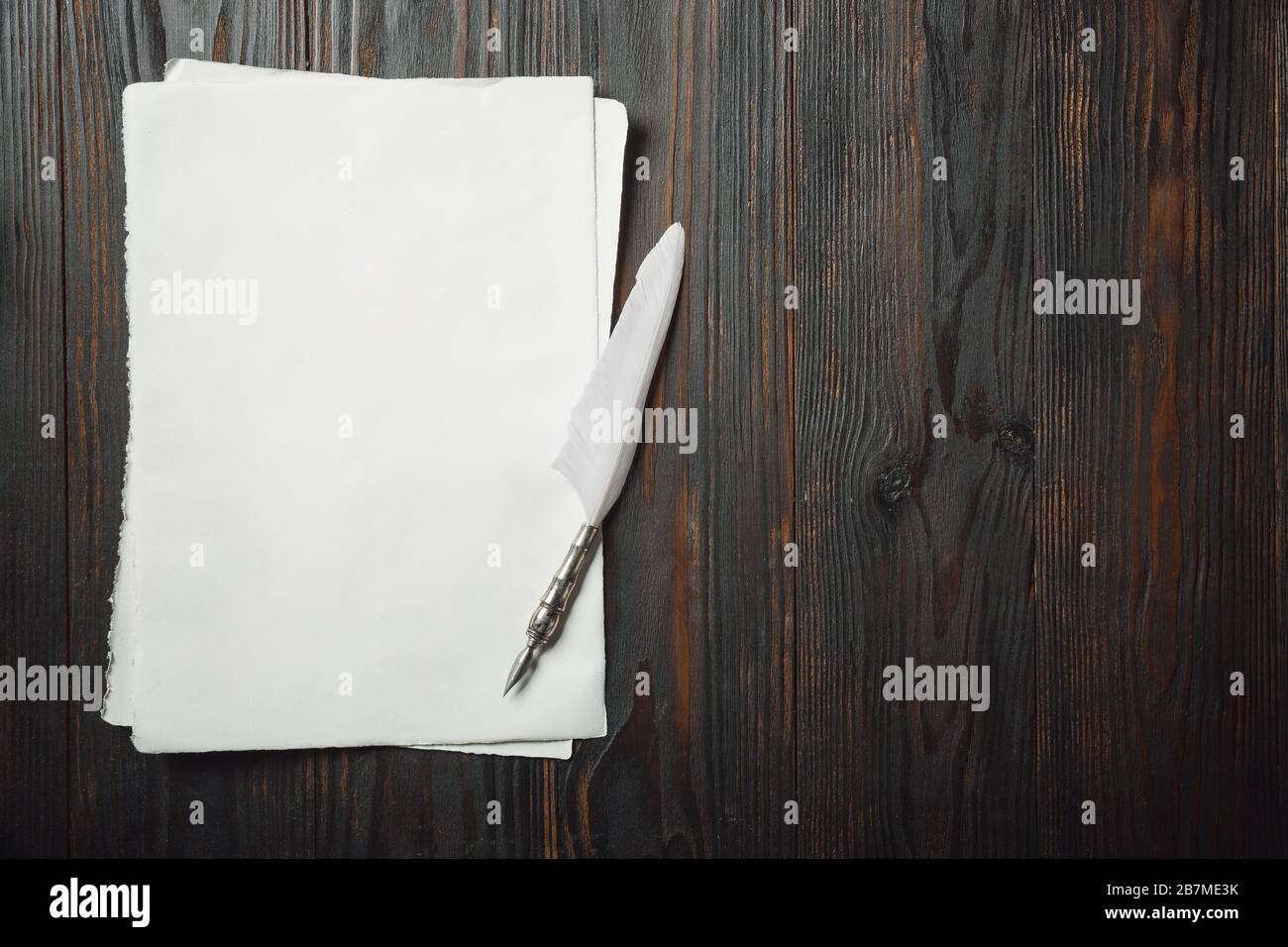 Old fashioned flat lay with letters or books, novels writing accessories on dark wooden background. Pen and white sheets. Vintage style, steampunk, gaslight concept. Copyspace for your proposal. Stock Photo