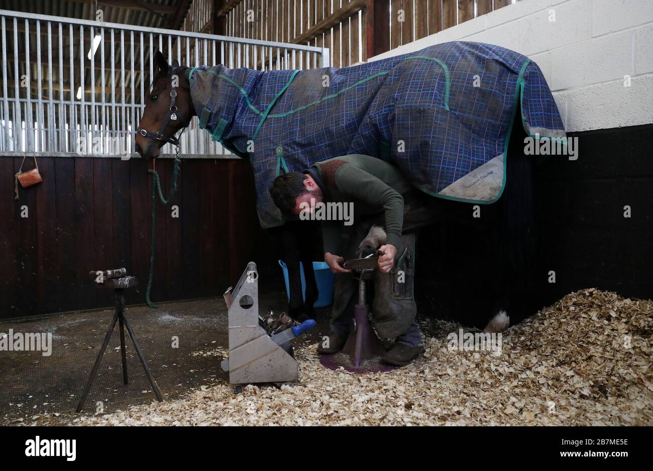 A farrier works on a horse during the visit to Samuel Drinkwater's