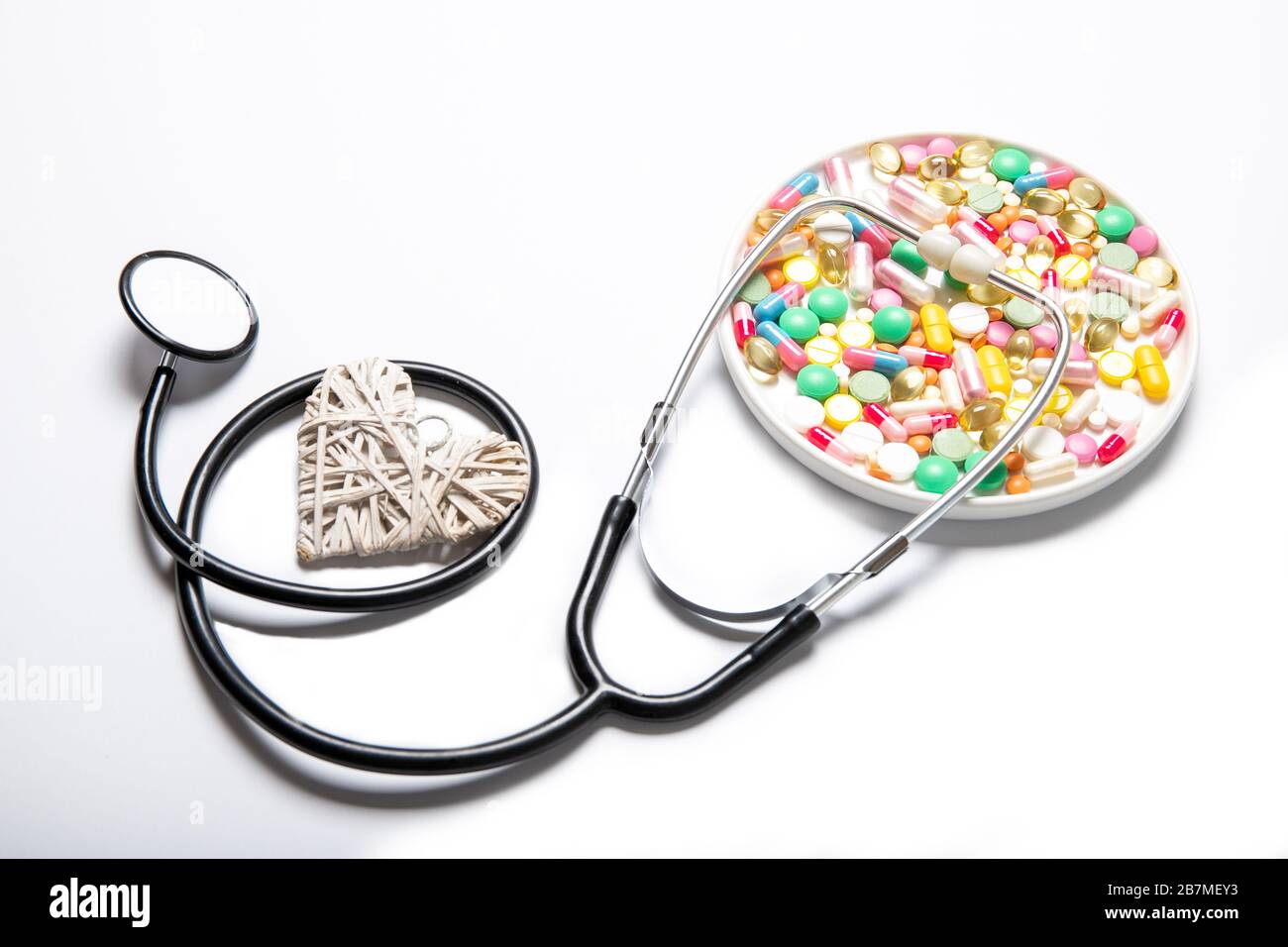 Multicolored pills decorative heart and stethoscope on a white background. The medicine Stock Photo