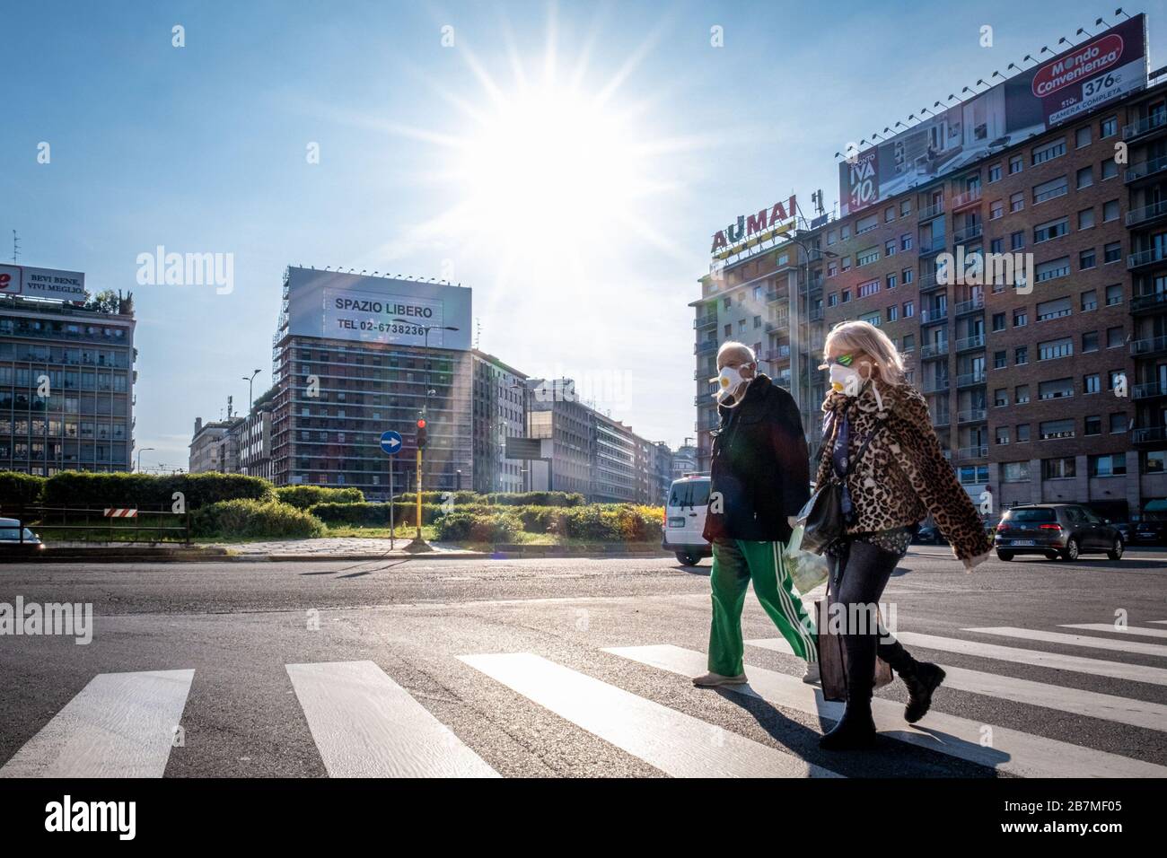 Milan - Coronavirus - An elderly man and woman with a mask cross the street in Piazzale Loreto Editorial Usage Only Stock Photo