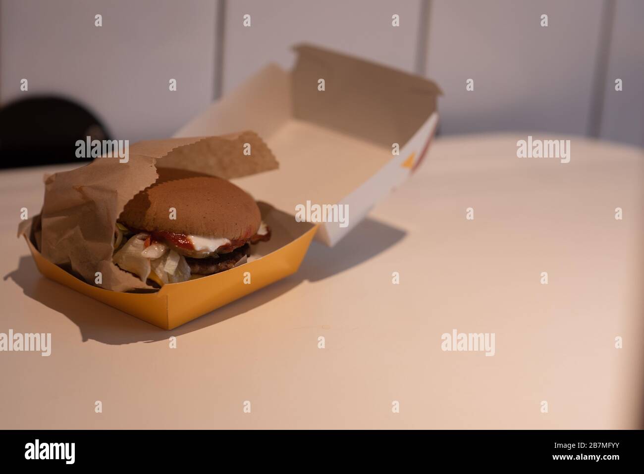 Hamburger in a take away container on table against white background Stock Photo