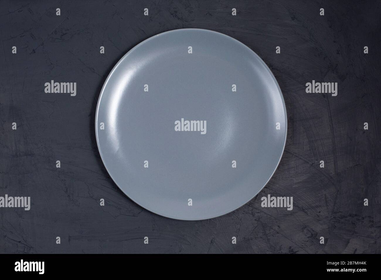 Empty ceramic gray plate on black table Stock Photo