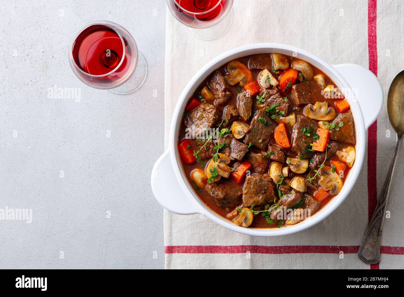 Beef bourguignon stew with vegetables and red wine. Grey background. Top view. Stock Photo