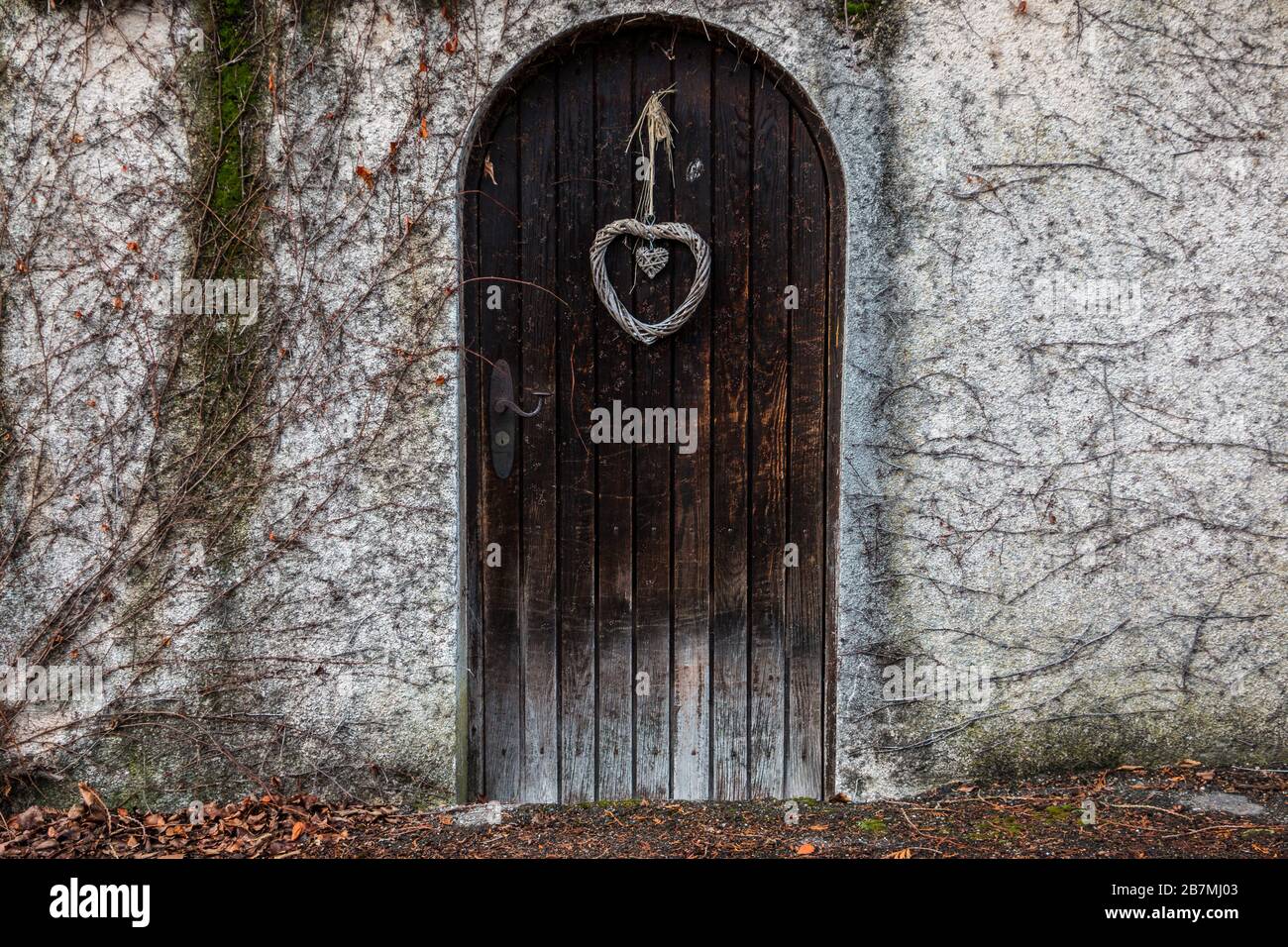 Old wooden door in a long stone wall Stock Photo - Alamy