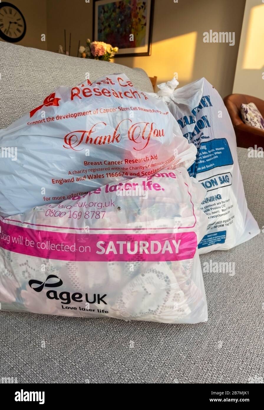 Close up of Age UK and other various Charity bags filled with clothing ready for collection England UK United Kingdom GB Great Britain Stock Photo
