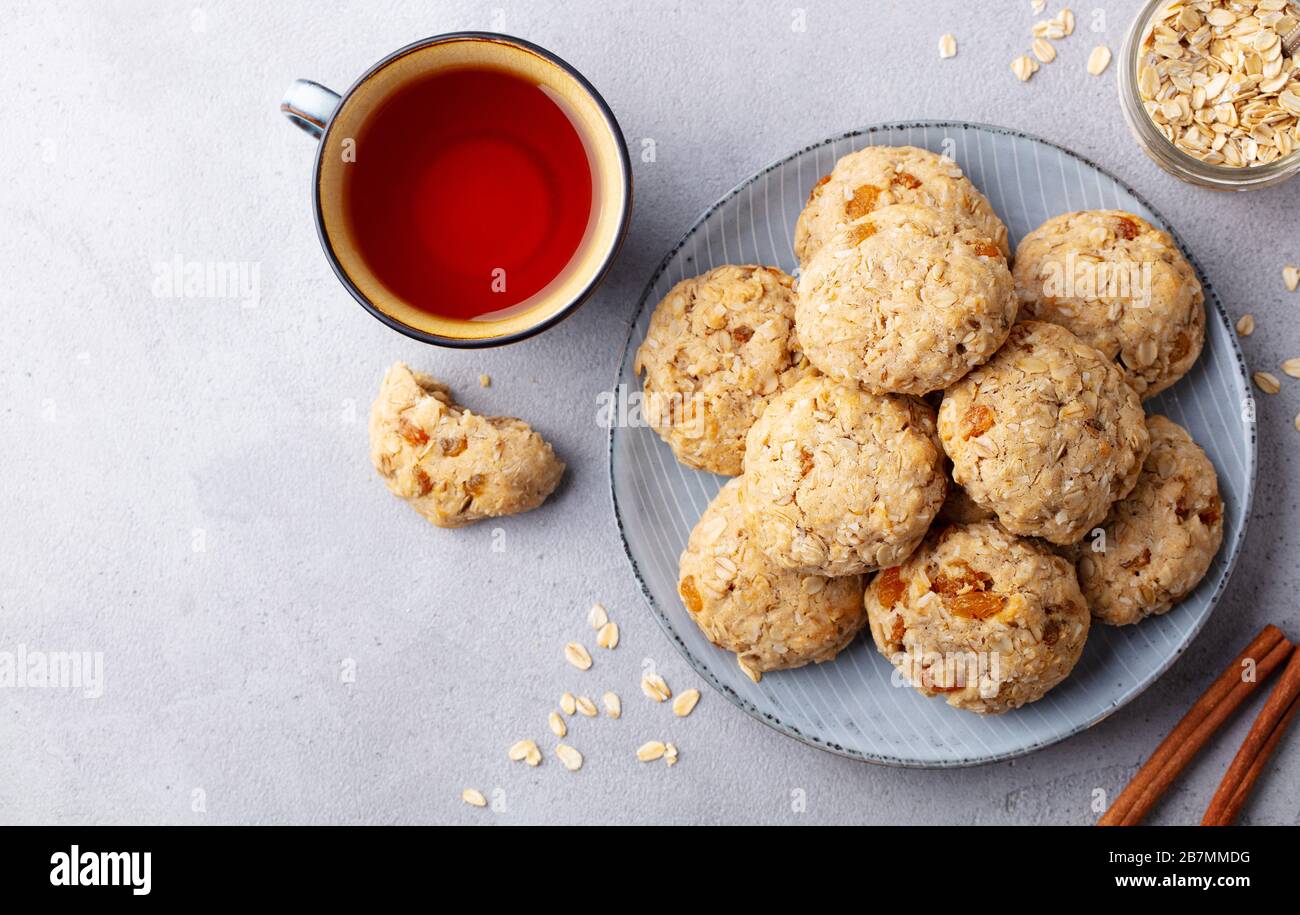 Healthy vegan oat cookies with cup of tea. Grey background. Top view. Stock Photo