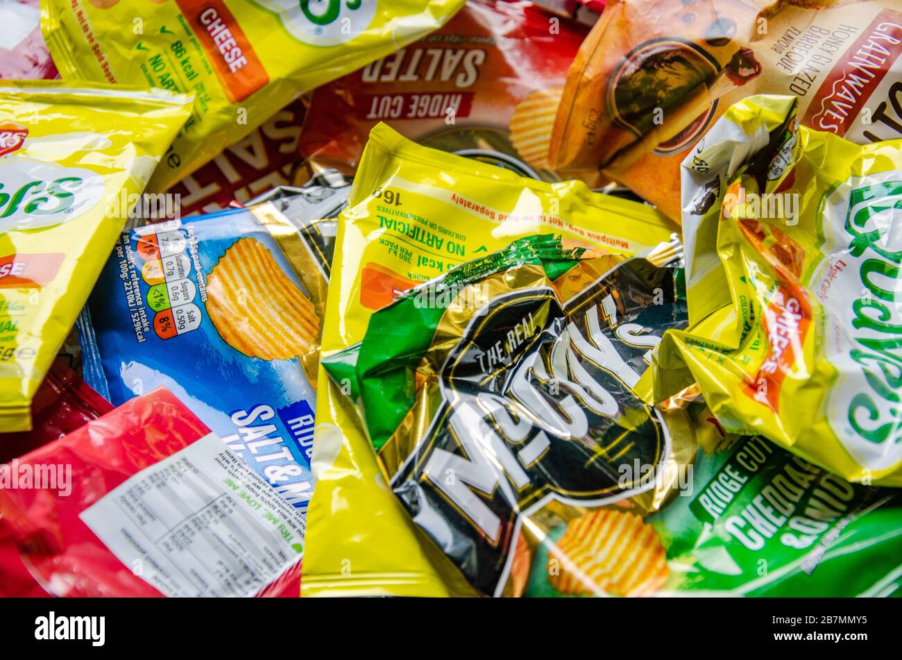 Close up view of empty crisp packets. They are colourful and made of plastic which is non-biodegradable and so environmentally unfriendly. Stock Photo