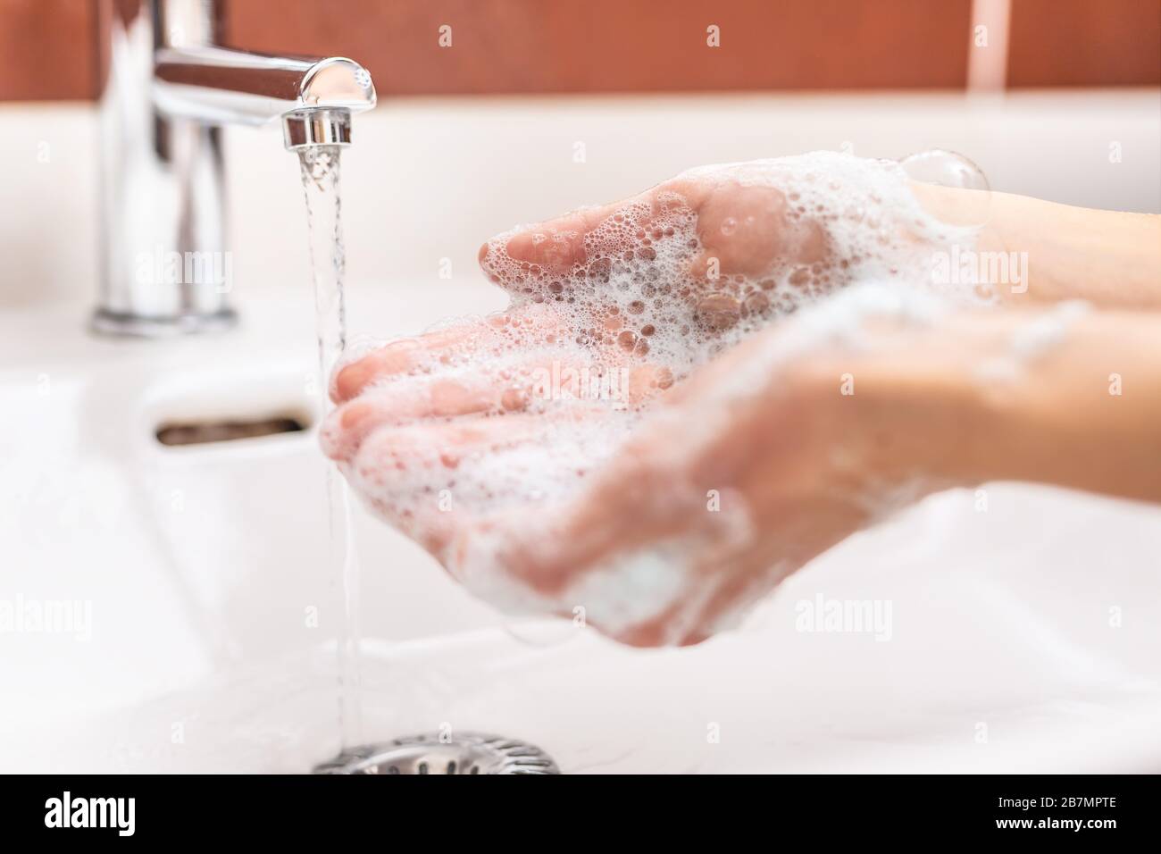 Washing hands with water and liquid soap in the bathroom. Hygiene anti ...