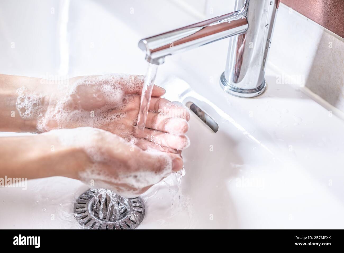 Washing hands with water and liquid soap in the bathroom. Hygiene anti ...