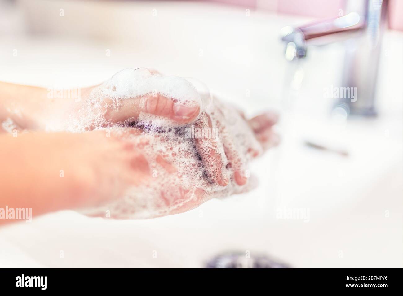 Washing hands with water and liquid soap in the bathroom. Hygiene anti ...