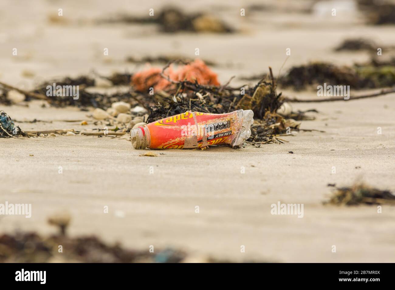 A plastic Lucozade drink bottle washed up on Harlech beach in West Wales UK an example of the many pieces of plastic in the sea around Britain Stock Photo