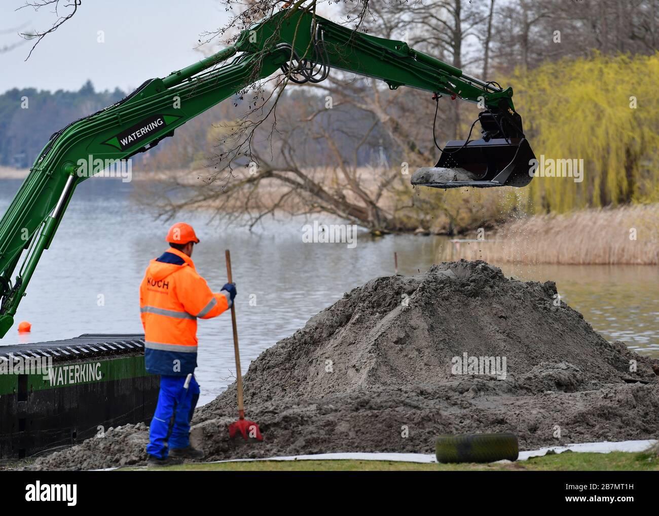 Wandlitz, Germany. 17th Mar, 2020. A worker of Koch Munitionsbergung GmbH  Oranienburg watches the dredger "Waterking", which dredges mud from the  near shore of the Wandlitzsee to the outside. Ammunition had been