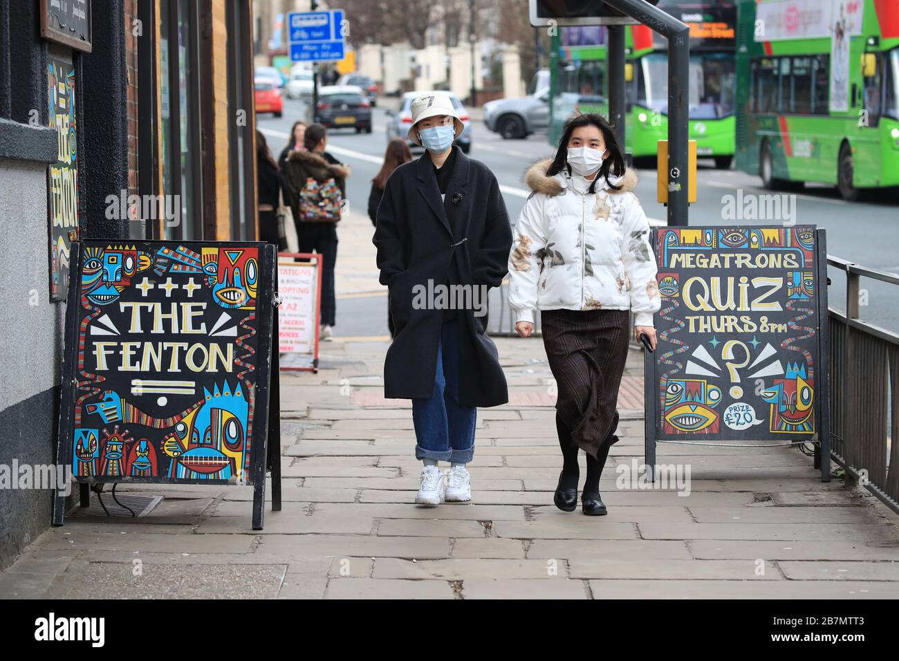 People wearing face mask in Leeds, West Yorkshire, the day after Prime Minister Boris Johnson called on people to stay away from pubs, clubs and theatres, work from home if possible and avoid all non-essential contacts and travel in order to reduce the impact of the coronavirus pandemic. Stock Photo