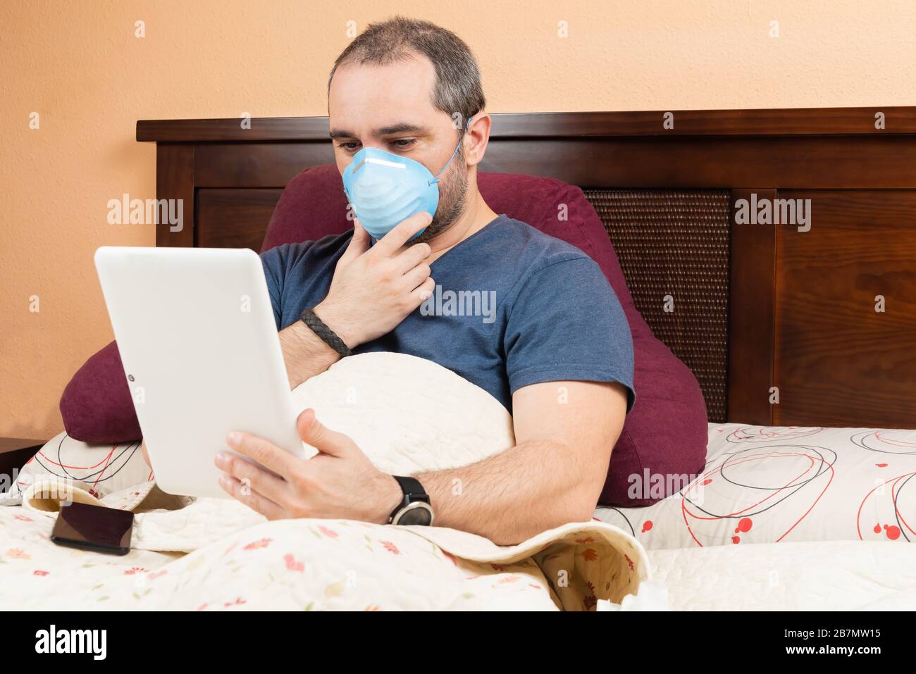 ill man using tablet in the bed. Stock Photo